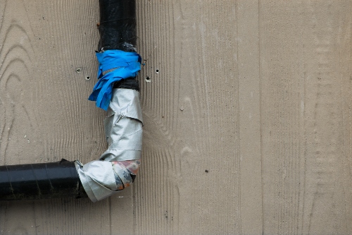 A pipe has tape and ties on it from being clogged.