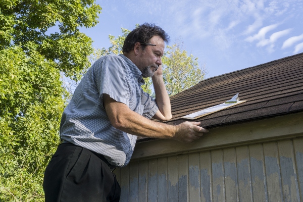 A homeowner looks over their roof inspecting it for leaks.
