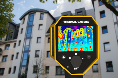 Outside an apartment building, a person holds up a thermal imaging camera showing 